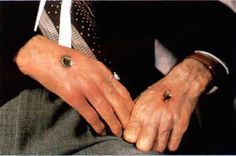 a man in a suit and tie holding his hands together with two rings on their fingers