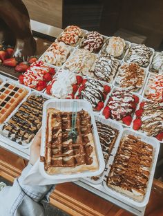 a person standing in front of a table filled with waffles and strawberries