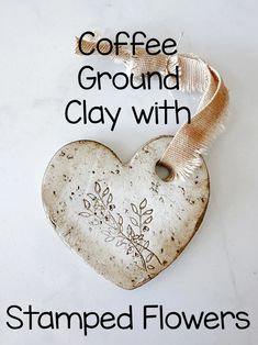 coffee ground clay heart with stamped flowers on it and the words, coffee ground clay with stamped flowers on it