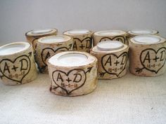 six wooden candles with hearts drawn on them