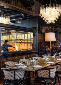 the dining room is set up for an event with chandeliers hanging from the ceiling