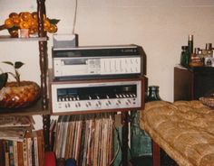 an old stereo system is stacked on top of each other in a room full of records