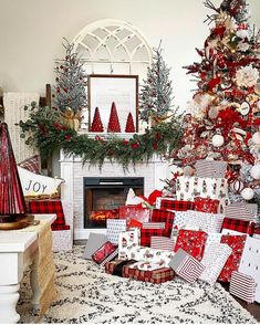 a living room decorated for christmas with red and white plaid pillows, tree, fireplace mantel and stockings