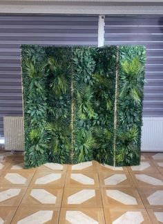 a room divider made out of green plants