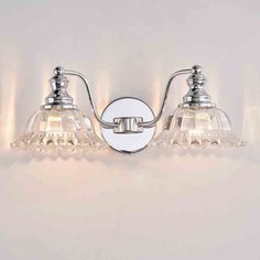 two light bathroom fixture in chrome finish with clear glass shades on the side and white background