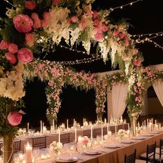 a long table covered in lots of flowers and candles