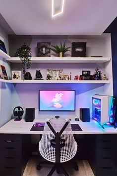 a desk with a monitor, keyboard and speakers on it in front of a book shelf