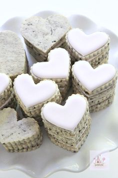 heart shaped cookies on a plate with white frosting