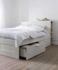 a white bed with two drawers underneath it