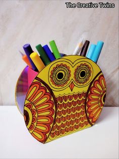 an owl shaped pencil holder with markers in it