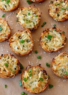 mini pizzas with cheese and green onions on a sheet of parchment paper, ready to be eaten