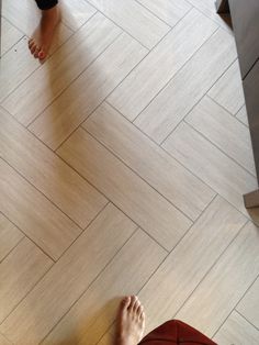 two people standing on the floor with their feet up