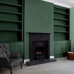 a living room with green walls and a fire place in the middle of the room