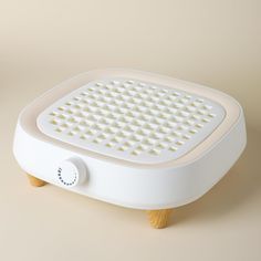 an electric foot bath with wooden legs on a beige background