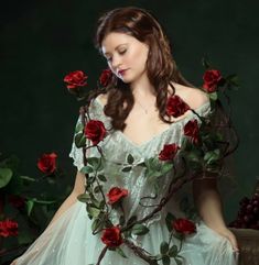 a woman in a white dress surrounded by red roses