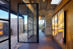 the hallway is lined with glass doors leading to an outdoor area that has stone walls and flooring