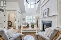 a living room filled with furniture and a fire place under a skylight above the fireplace