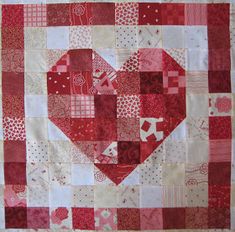 a red and white quilt with a heart on it