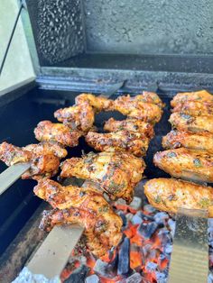 chicken is being cooked on the grill with tongs