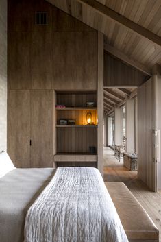 a bedroom with wood paneling and built - in bookshelves on the wall