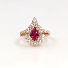 --- Handmade in the United States--- Made to Order--- Metal: Solid 14K Gold ( White, Rose, Yellow Gold )--- Band Width: 3.0 mm--- Center Stone: Lab Created Ruby--- Center Stone Size: 8mm x 6mm--- Center Stone Carat Weight: Approx 1.3 ct--- 100% Real Natural Diamond--- Non-Conflict Diamonds--- Diamond Shape: Pear / Round--- Diamond Cut Grade: Very Good--- Diamond Cutting Style: Brilliant Cut--- Diamond Color: G - H (White)--- Diamond Clarity : SI1-2 (Eye Clean)--- Diamond Quantity: 43--- Diamond Ruby Engagement Ring Gold, Unique Womens Wedding Rings, Engagement Ring Ruby, Ruby Diamond Engagement Ring, Ruby Wedding Ring, Ruby Wedding Rings, Pear Wedding Ring, Stacked Wedding Rings, Luxurious Fashion