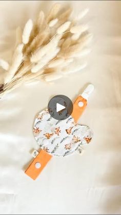 an orange and white object sitting on top of a bed next to some dry grass