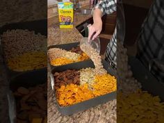 a person standing in front of two trays of food on top of a counter