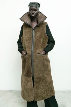 100% shearling sheep fur with 100% vegetable dyed leather/ long vest/ zipper closure/ front pockets/ high collar Amam is 5'9" size 2 wearing size S Sleeveless Fur Coat With Faux Fur Lining For Fall, Sleeveless Faux Fur Coat For Fall, Sleeveless Mink Outerwear For Winter, Fall Sheepskin Sleeveless Vest, Sleeveless Sheepskin Vest For Fall, Sleeveless Mink Outerwear With Faux Fur Lining, Vest Zipper, Womens Outerwear, Luxury Outerwear