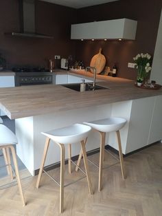 three stools are in front of the kitchen counter