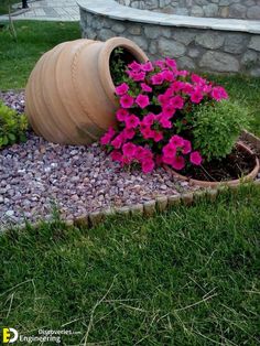 a potted planter with pink flowers in it sitting on the side of a stone wall