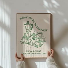 a person holding up a poster with the words home made breakfast in green on it