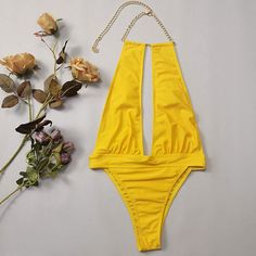 Wear confidently and turn heads with this striking this sexy yellow bathing suit. This stunning one piece swimsuit features a halter neck with metallic chain detailing that adds a touch of glamour to your look, removable soft padding cups for comfort, an alluring cut-out at the middle to enhance your curves, a high rise banded design at the waist highlighting of this swimsuit, giving it a unique and trendy look, and the high leg bikini bottom has cheeky Brazilian cut, perfect for a day of fun in the sun. Size (in)BustWaistHipS28-3126-3034-36M29-3328-3136-38L31-3529-3338-40 Summer Club Bodysuit With Halter Neck, Summer Club Halter Neck Bodysuit, Summer Halter Neck Bodysuit For Club, Halter Neck Swimwear For Club And Beach Season, Summer Beachwear With Chain Strap, Gold Halter Neck Swimwear For The Beach, Gold One-piece Swimwear For Poolside, Yellow Backless Bodysuit For Beachwear, Gold Halter Neck Beachwear Swimwear