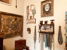 there are many necklaces hanging on the wall in this room with pictures and jewelry