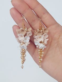 https://purplebeestudio.etsy.com Handmade chandelier earrings in shades of beige inspired by cappuccino. The flowers are handmade from polymer clay by me without using any molds. These very elegant delicate earrings will become your favorits for many occasions. Earrings made with brass ear wire. The earrings are very light and comfortable to wear all day. SHIPPING: Your order will be dispatched in a securely packed cardboard box. Product care:  - To ensure the product quality and durablility, avoid contact with water, lotion, perfumes and household cleaners and chemicals. - You can clean the products with a slightly damp soft fabric.  - Sharp objects can damage the clay surface. - When not in use, store in a dry, seperate box. Thank you for visiting my shop! If you have any special request Bridal Party Earrings, Handmade Chandelier, Jewelry Clay, Wedding Bridesmaid Jewelry, Clay Flower, Floral Jewelry, Jewelry Bridesmaid, Party Earrings, Floral Jewellery