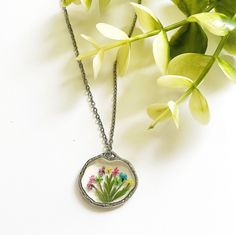 Indulge in the delicate charm of this Pressed Multi-Colored Wildflower Necklace, a burst of vibrant flowers and natural beauty that effortlessly complements your everyday style! Crafted from real multi-colored dried wildflowers and carefully encased in resin, this necklace captures the timeless allure of nature, making it a perfect gift to brighten someone's day or a delightful addition to your daily ensemble. Handmade with love, each piece is a unique work of art, showcasing the diversity of nature's palette. 💐 Details: - Necklace Material: silver plated stainless steel - Necklace Length: 18 inches with a 2 inch lobster claw extender for a customizable fit - Bezel Material: silver plated alloy - Nature's Uniqueness: Please note that each flower is a masterpiece of nature, resulting in sl Dainty Multicolor Flower Necklace, Bohemian Birth Flower Pendant Necklace, Botanical Necklace With Flower Pendant And Charm, Multicolor Flower Jewelry With Pressed Flowers, Multicolor Flower Shaped Jewelry With Pressed Flowers, Flower Charm Necklaces With Pressed Flowers, Bohemian Flower-shaped Nickel Free Necklace, Bohemian Flower-shaped Nickel-free Necklace, Bohemian Birth Flower Necklaces