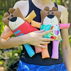 a woman holding three stuffed animals in her hands