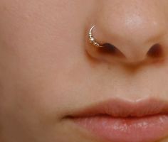 a close up of a person's nose with a small nose ring on it