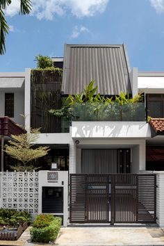 a modern house with an iron gate in the front yard