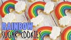 rainbow sugar cookies with white frosting in the shape of clouds and a rainbow on top