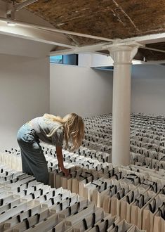 a woman bending over in an empty room