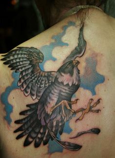 the back of a woman's shoulder with an eagle tattoo on it, flying through the air