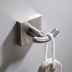 a hook is attached to the side of a white wall with a rope hanging from it