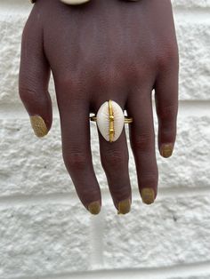 This artisanal Cowry shell and Brass adjustable Ring adds a touch of bohemian charm to any outfit. Handmade with precision and attention to detail, each ring offers a unique and stylish look. A perfect addition to your jewelry collection. sold as 1 per price Bohemian Toe Ring Jewelry For Beach, Shell-shaped Brass Jewelry For The Beach, Handmade Open Ring Jewelry For Beach, Adjustable Bohemian Style Ring Jewelry, Adjustable Bohemian Style Ring, Beach Toe Ring Jewelry, Brass Shell Jewelry For Beach, Beach Shell Brass Jewelry, Artisan Adjustable Ring Jewelry