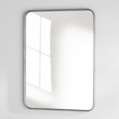 a white bathroom mirror sitting on top of a wall