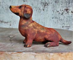 a dog figurine sitting on top of a wooden table next to a wall