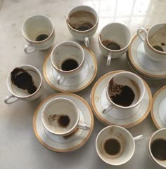 coffee cups and saucers filled with different types of coffee on a white counter top