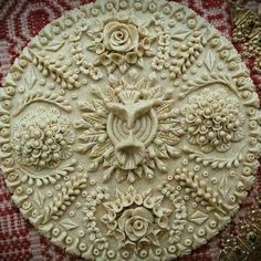 an intricately designed piece of art is shown on a tablecloth with gold trimmings