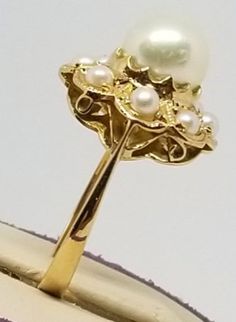 "We do not check prongs for wear or stones for looseness. All items are sold as is-noting that we are a resale shop so everything here had a previous owner! We will include flaws in the description when noted. This is one of the reasons our items are more affordable than new at a jewelry store. Vintage 18K Yellow Gold Pearl Ring, Size 6. Stamped K18 inside band. Main Pearl is 7.2mm others are 2.5mm. Weighs 2.1 dwt. Please stop in often as we will be adding additional vintage fine jewelry beautie 14k Gold Rings With Aaa Quality For Anniversary, Aaa Quality 14k Gold Rings For Anniversary, High Quality 14k Gold Rings For Anniversary, Gold Cluster Pearl Ring For Formal Occasions, Heirloom High Luster Rings For Anniversary, Vintage High Quality Jewelry For Formal Occasions, Elegant Gold Pear-shaped Cluster Ring, European Jewelry, Gold Pearl Ring