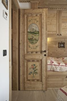 an open door leading to a bedroom with wood paneling and paintings on the wall