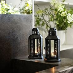 two black lanterns sitting on top of a counter